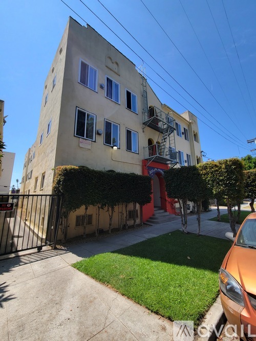 A white building with a red staircase outside.