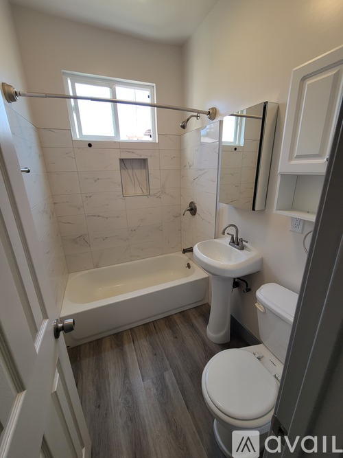 A bathroom with a tub, toilet, and sink.