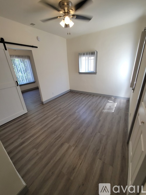 A room with wooden flooring and a ceiling fan.