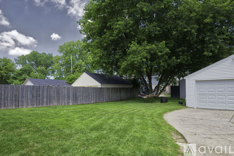 A backyard with a white garage and a wooden fence.