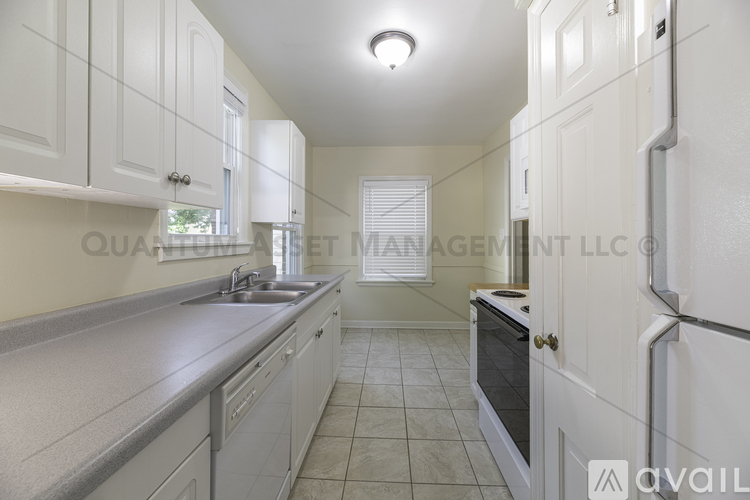 A kitchen with white cabinets and a countertop.