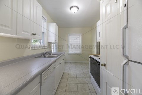 A kitchen with white cabinets and a countertop.