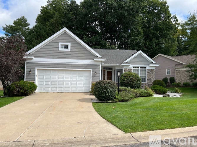 A two-story house with a garage and a driveway.