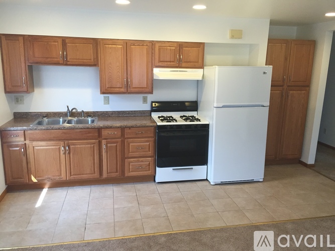 A kitchen with wooden cabinets and a white refrigerator.