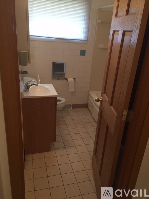 A bathroom with a sink, toilet, and a window.