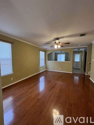 A room with wooden flooring and a ceiling fan.