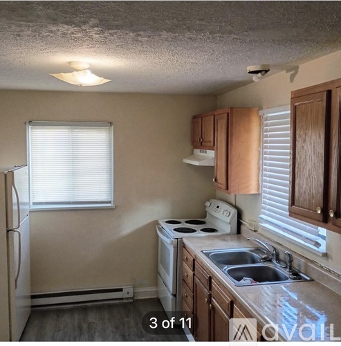 A kitchen with white appliances and wooden cabinets.