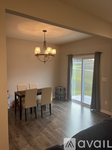 A dining room with a table and chairs and a chandelier.