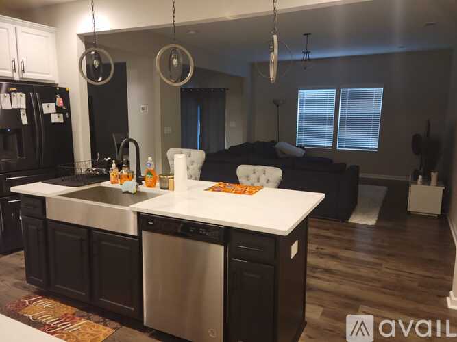 A modern kitchen with black cabinets and a white island.