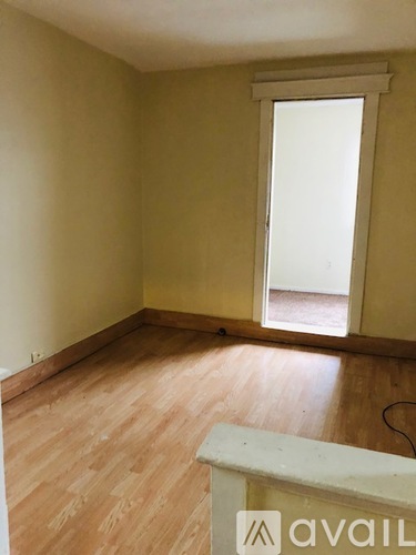 A room with wooden flooring and a window letting in light.