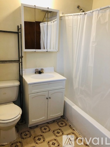 A white toilet sits next to a sink in a small bathroom.