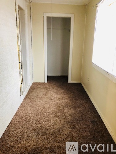 A room with a carpeted floor and a doorway leading to another room.