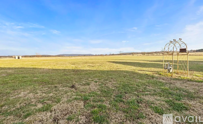 A field with a metal structure in the middle under a clear blue sky.