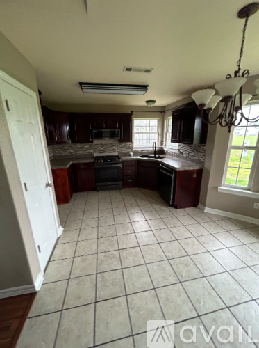 A kitchen with white tiled floors and a chandelier.
