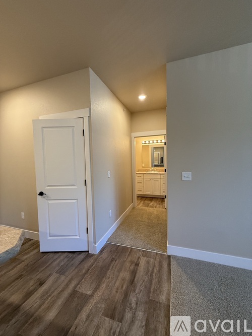 A room with a white door and a carpeted floor.