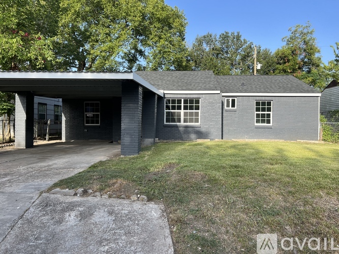 A house with a grey roof and a garage door is for sale.