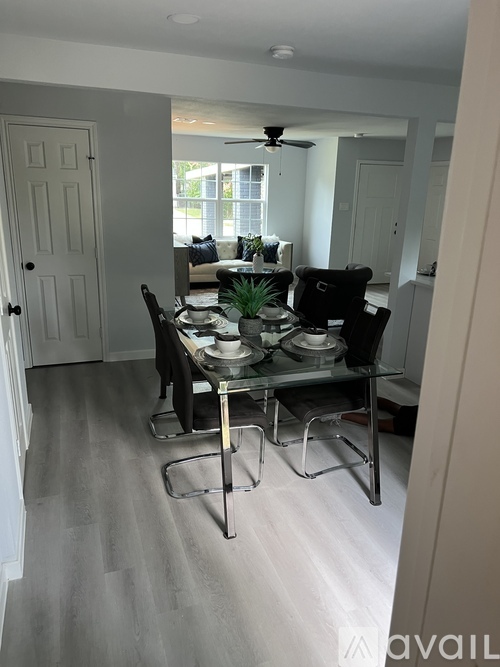 A dining room with a table set for two and a ceiling fan.