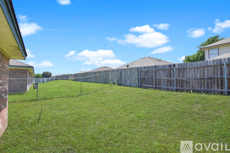 A backyard with a wooden fence and a grassy area.