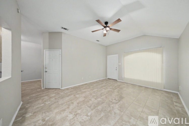 A spacious room with a ceiling fan and lighting fixture.
