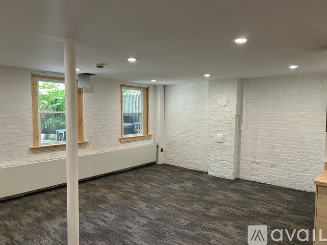 A room with white walls and a grey carpet.