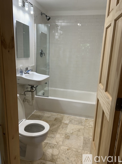 A bathroom with a toilet, sink, and shower.
