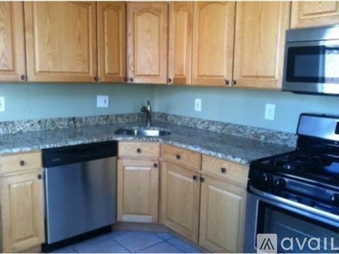 A kitchen with wooden cabinets and granite countertops.