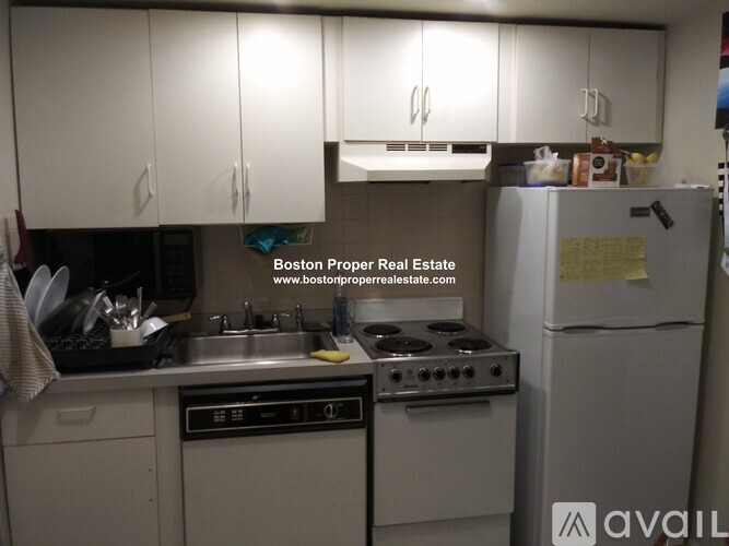 A kitchen with white cabinets and appliances is for sale.