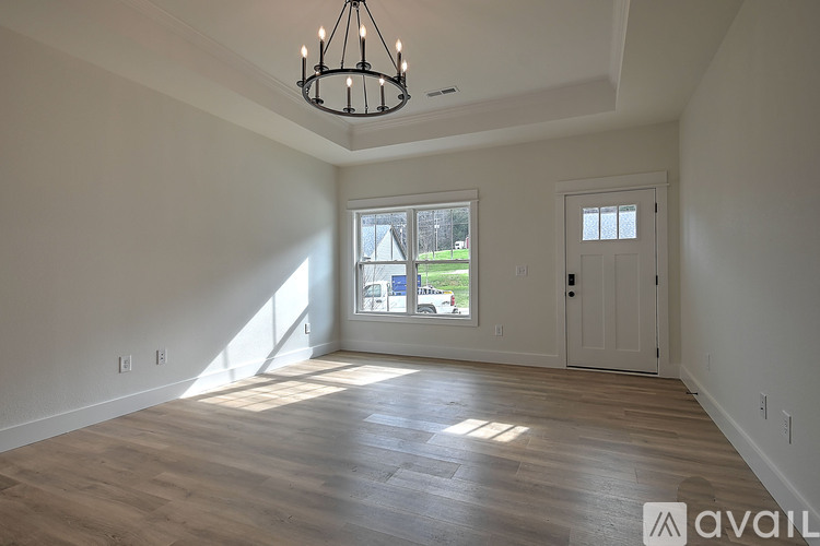 A room with wooden floors and a chandelier hanging from the ceiling.
