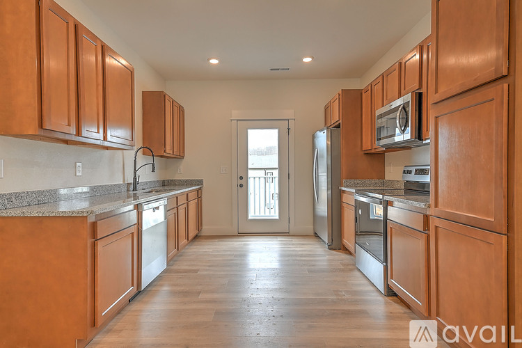 A kitchen with wooden cabinets and a granite countertop.