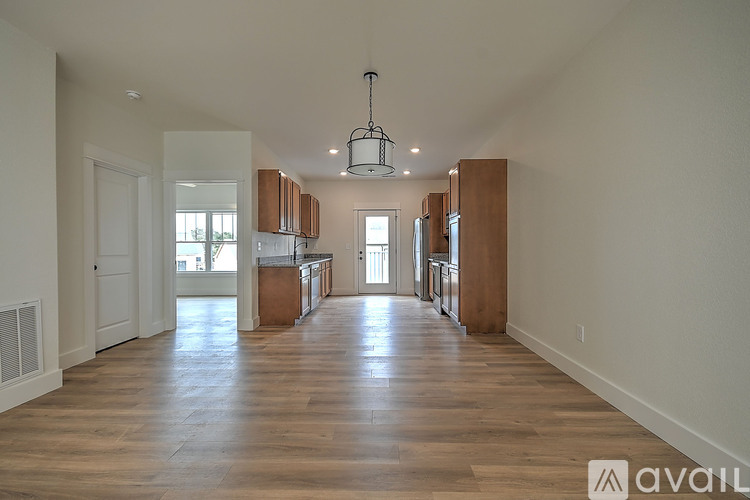A spacious living room with wooden floors and a central island.