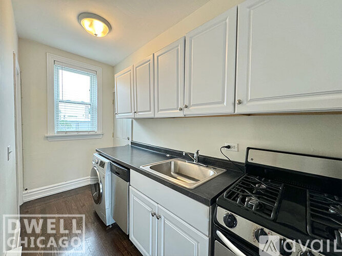 A kitchen with white cabinets and a black stove top.