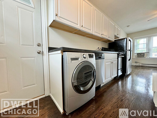A kitchen with a white door and a black refrigerator.