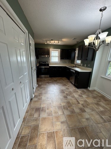 A kitchen with tile flooring and a chandelier.
