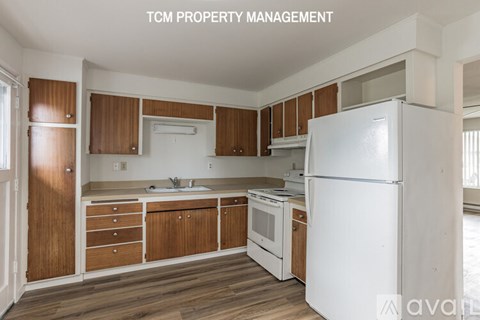 A kitchen with wooden cabinets and a white refrigerator.