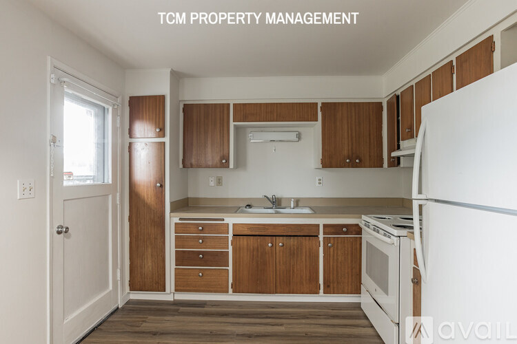 A kitchen with wooden cabinets and a white refrigerator.