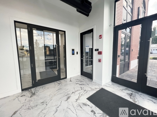 A hallway with marble floors and black doors.