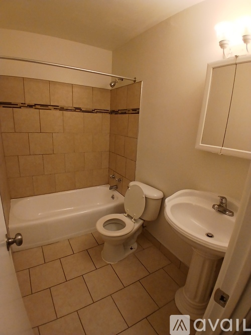 A bathroom with a toilet, sink, and bathtub.