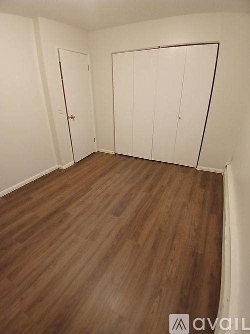 A room with wooden flooring and white doors.