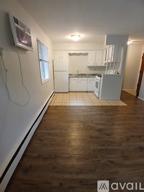 A kitchen with white cabinets and a wooden floor.