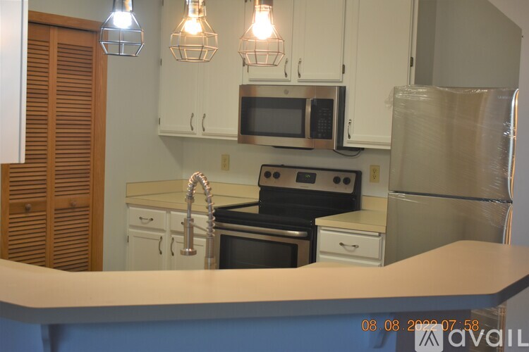 A kitchen with a stove, microwave, and refrigerator.