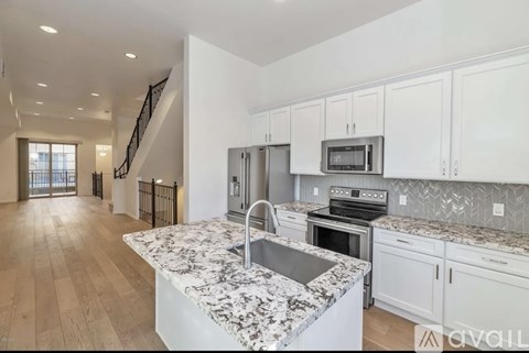 A kitchen with granite countertops and white cabinets.