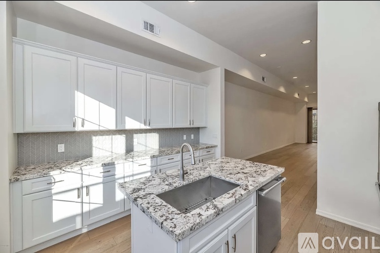 A kitchen with granite countertops and white cabinets.