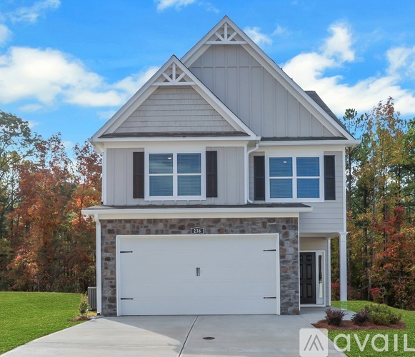 A modern house with a white garage door is for sale.