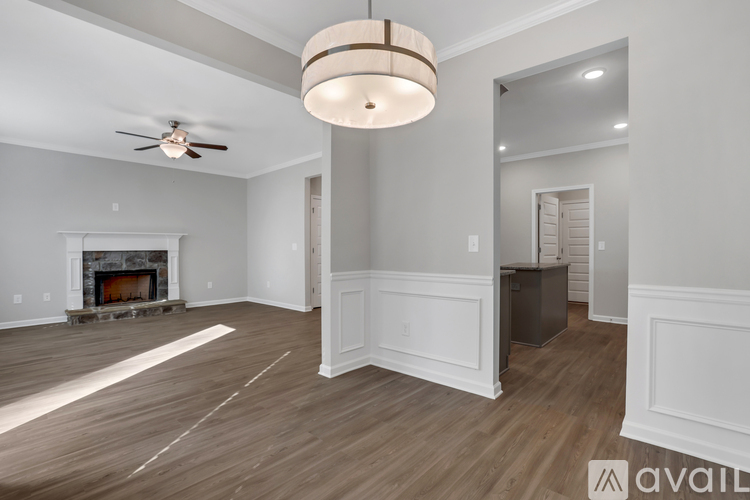 A spacious living room with wood flooring and a fireplace.