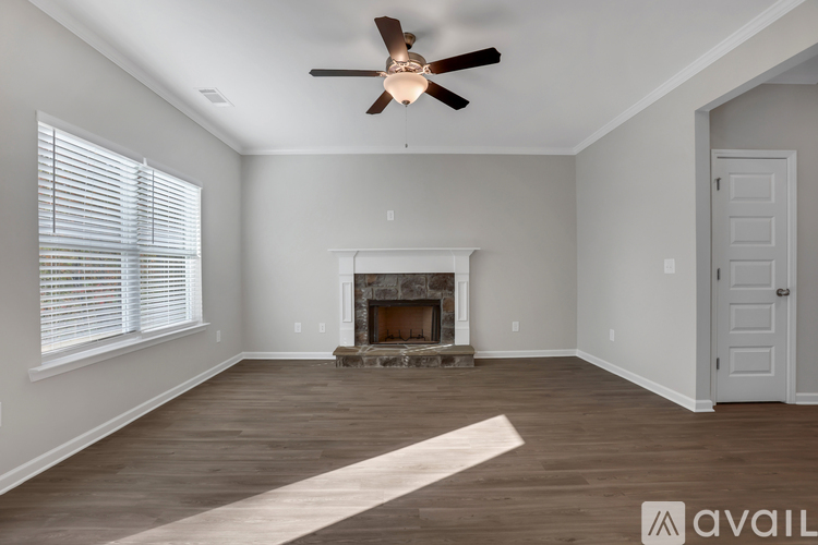 A spacious room with a fireplace and a ceiling fan.