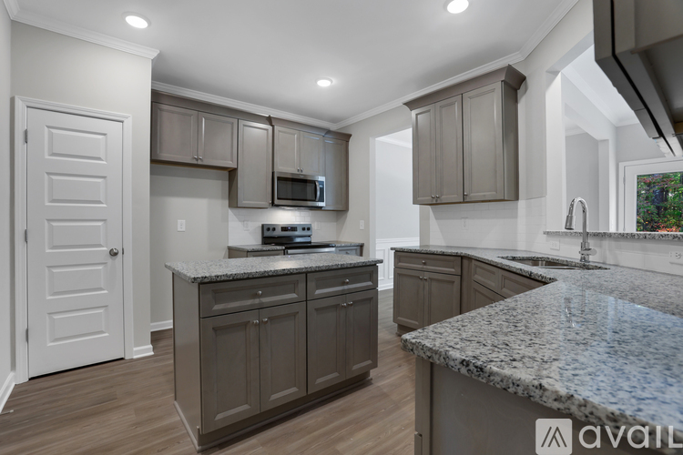 A kitchen with granite countertops and a microwave above the stove.