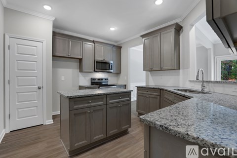A kitchen with granite countertops and a microwave above the stove.