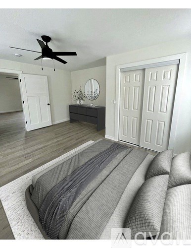 A living room with a grey couch and a ceiling fan.