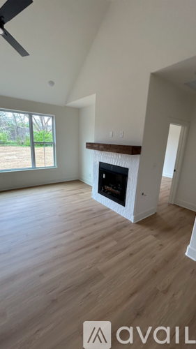 A room with a fireplace and a fan on the ceiling.