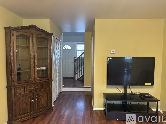 A living room with a wooden cabinet, a black television, and a glass door.